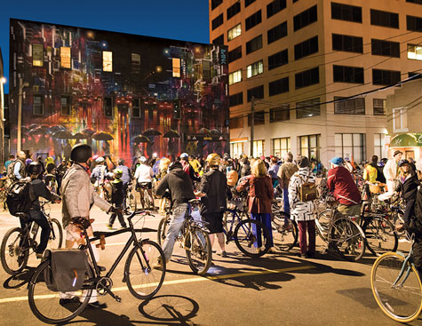people outside on bikes stopped to view a painted mural during the disco bike ride during the annual art festival in moncton, new brunswick, canada