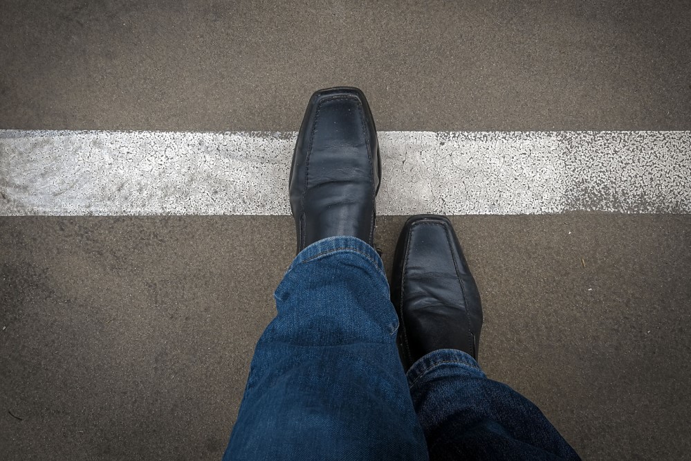 Image of a person crossing a line on pavement