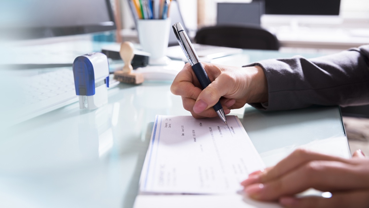 Image of person signing a check