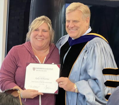 Kelly DiMartino holding her certificate from the program