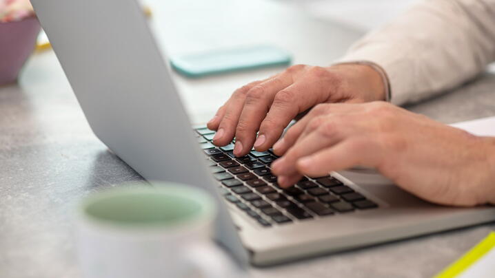 Typing a message. Close up picture of a man working on a laptop