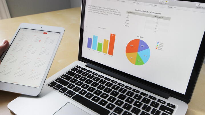 Image of laptop and tablet with charts and graphs