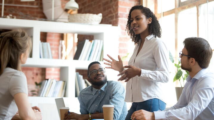 Image of person speaking to others at conference table