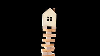 Image of a house on top of jenga blocks