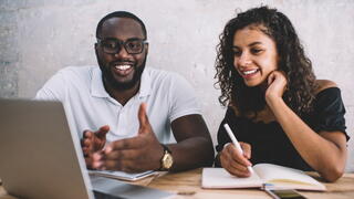 Image of two people working together